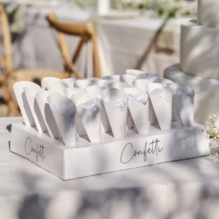 Witte confettistandaard met witte confetti staat op een tafel onder een boom in de zon