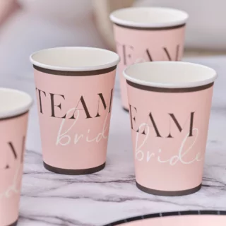 Papieren bekers in het roze en zwart met de tekst team bride staat op een marmeren tafel