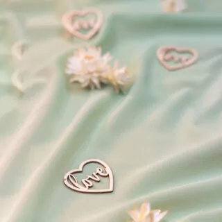 houten hartjes met de tekst love op tafel met saliegroene loper