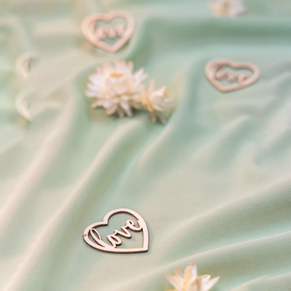houten hartjes met de tekst love op tafel met saliegroene loper