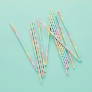 Regenboog rietjes in pasteltinten op een mintgroene achtergrond