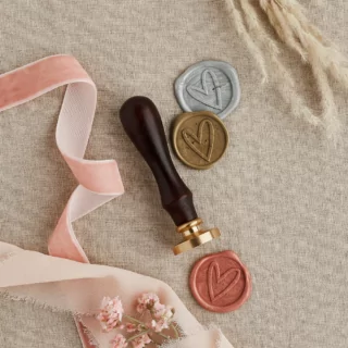 stempel voor was met een hartje ligt op een jute kleed nasat een roze lint en graan