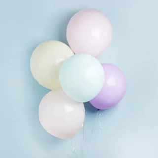 pastelkleurige reuzeballonnen voor een blauwe muur