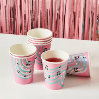 roze bekers met muzieknoten en sterren en mintgroene en iridescent strepen liggen op een witte tafel