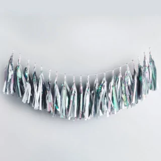 iridescent tassel slinger hangt voor een grijze muur