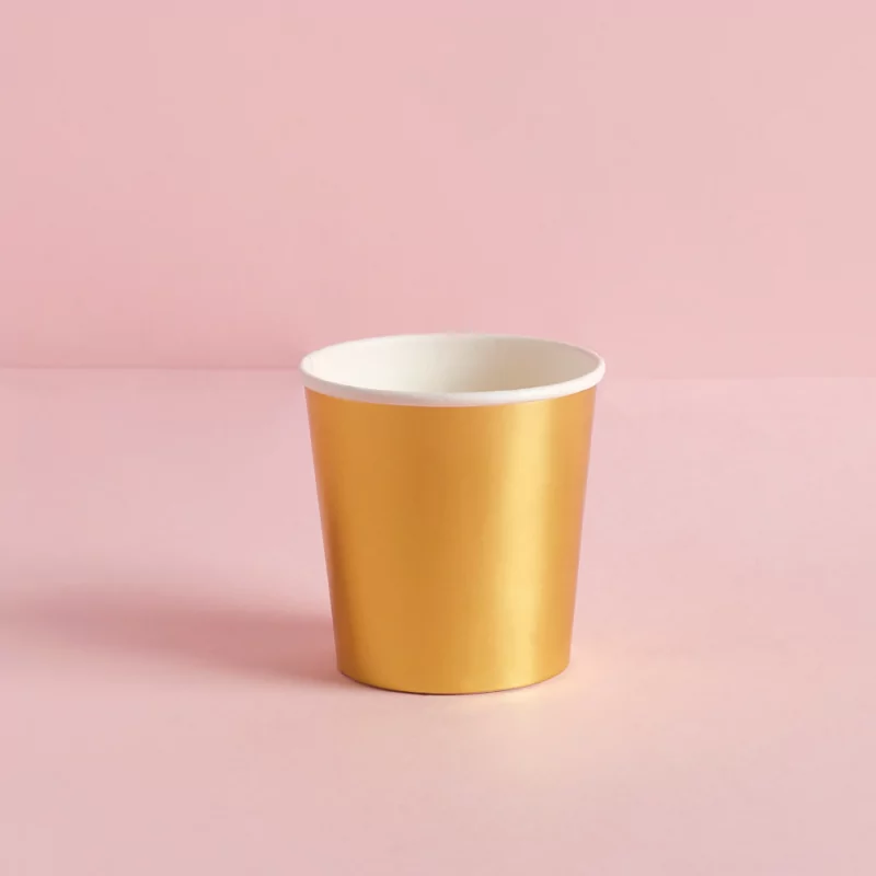 Gouden shot bekertje op een roze achtergrond