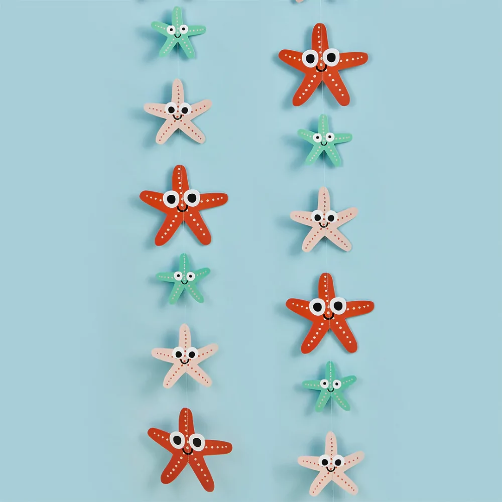 slinger met zeesterren met schattige gezichtjes in het oranje, roze en mintgroen voor een blauwe muur