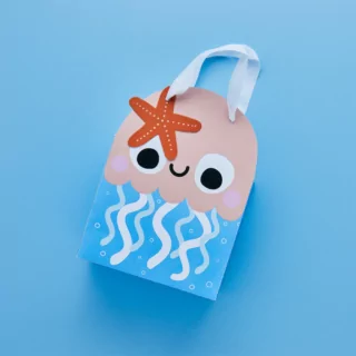 cadeautasje in de vorm van een kwal met een zeester op een blauwe achtergrond