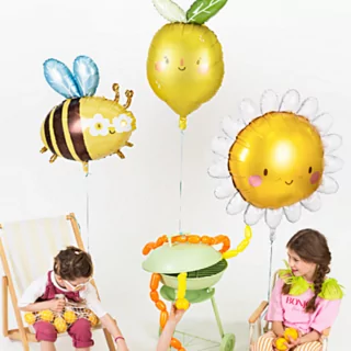 kinderen met folieballonnen in de vorm van een hommel, een citroen en een zonnetje