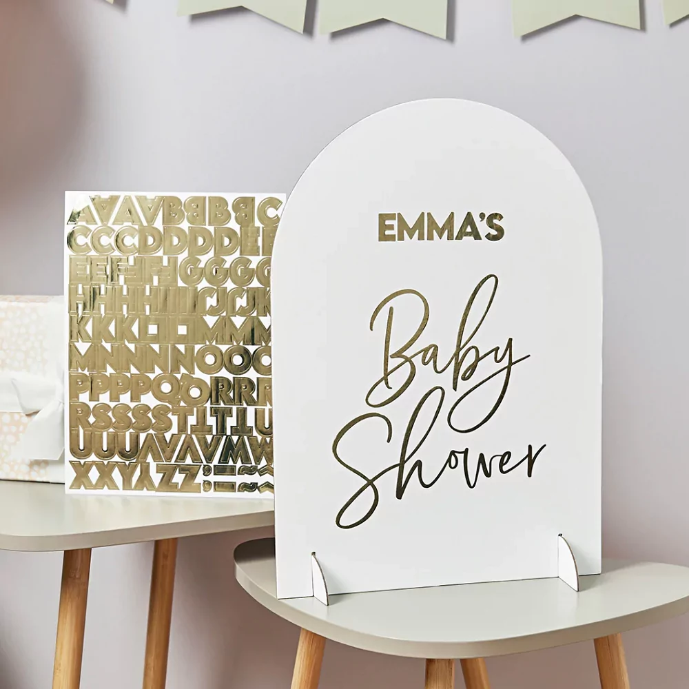 wit bord in grafsteenvorm met gouden tekst baby shower en gouden stickers