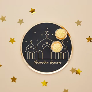 Zwart bordje met gouden details en twee cupcakes erop