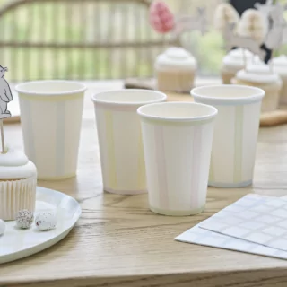 Bekers met pastel kleuren en strepen staan op een houten tafel