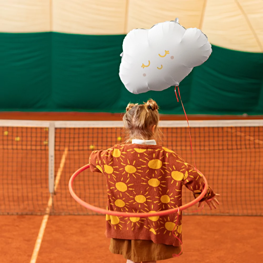 meisje op een tennisbaan met een wolk ballon