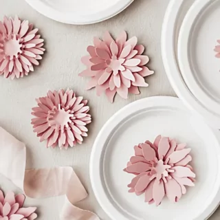 Tafel versierd met katoenen kleed en roze bloemen