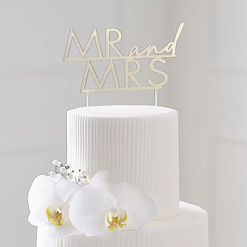Gouden cake topper van acryl met de tekst mr and mrs zit in een witte taart met bloemen
