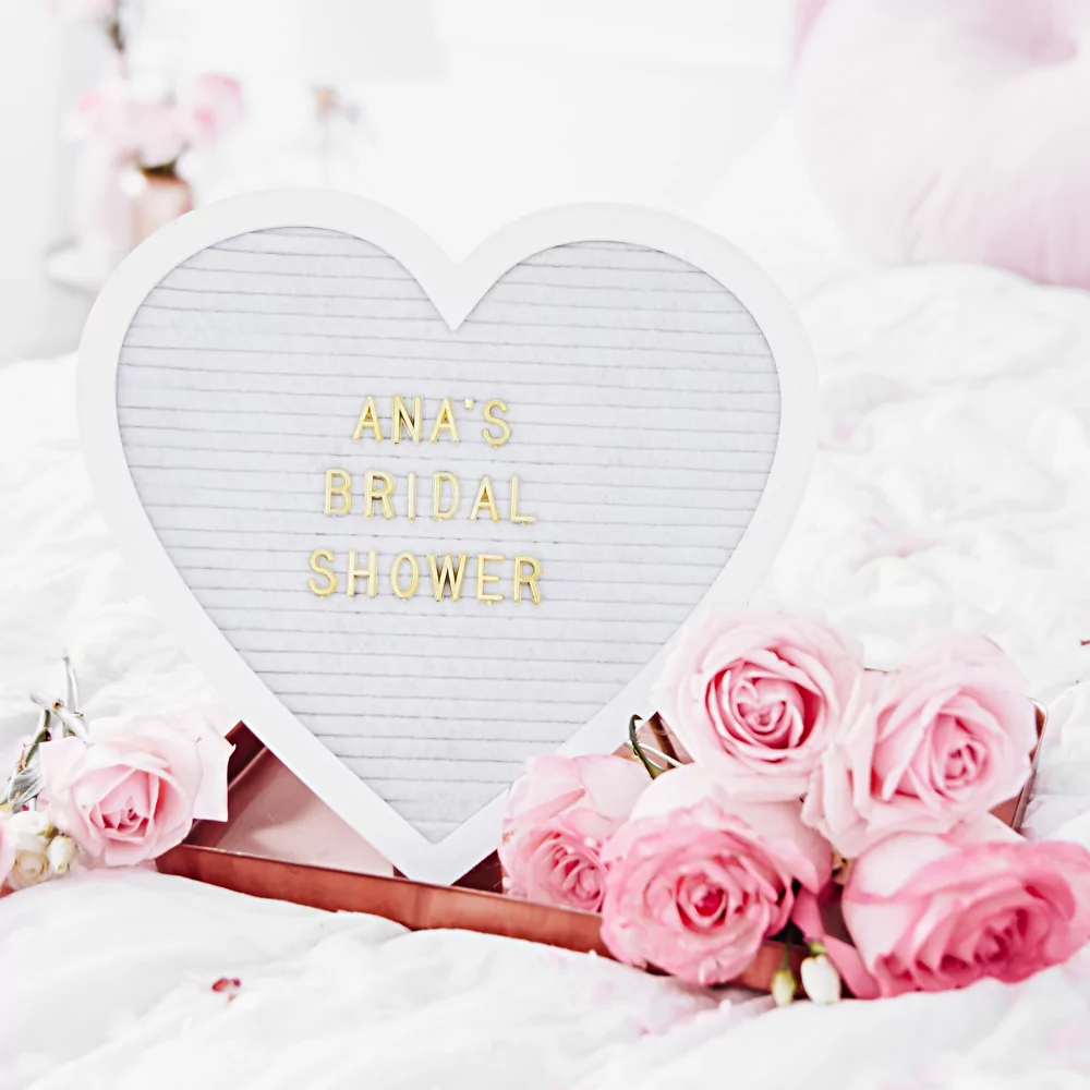wit letterbord in de vorm van een hart met gouden letters