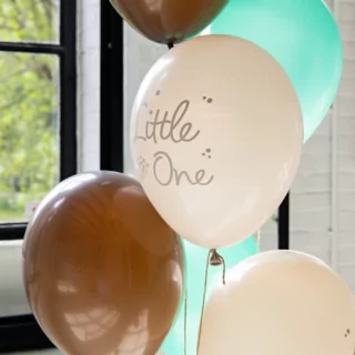 bruine, creme, grijze en mint ballonnen met een bloesem print en de tekst little one voor een babyshower hangen voor een raam met een zwart kozijn