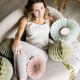 vrouw ligt op een bank met creme honeycombs en waaiers