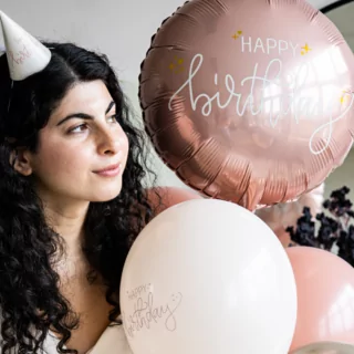 roze folieballon met de creme tekst happy birthday en gouden sterren