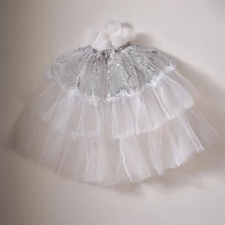 witte tule cape met zilveren pailletten hangt aan een witte kledinghanger