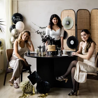 drie vrouwen op een verjaardag met zwart en creme thema versiering