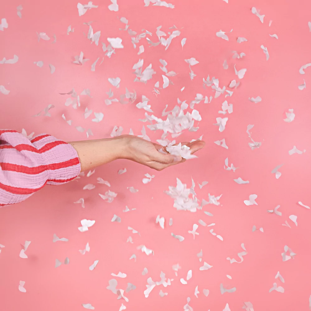 witte vlinder confetti fladdert voor een roze achtergrond