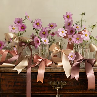 vaasjes met bloemen versierd met perzik goud en rosé gouden lint