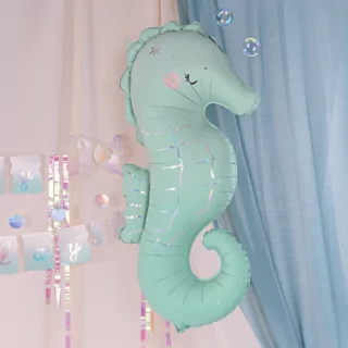 folieballon zeepaardje mintgroen met iridescent details hangt voor een lichtblauw doek
