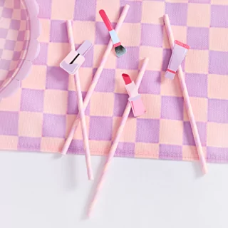 lila rietjes met makeup erop zoals een lippenstift, kwast, nagellak en creme