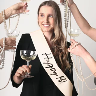 meisje met een creme sjerp met de zwarte tekst happy 18