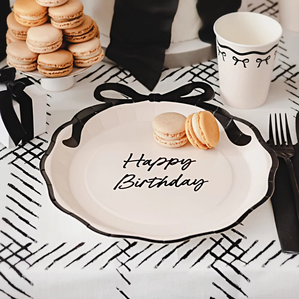 creme bordje met zwarte tekst happy birthday en een zwarte strik