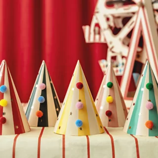 circus feesthoedjes met pom poms in het rood, groen, geel en roze